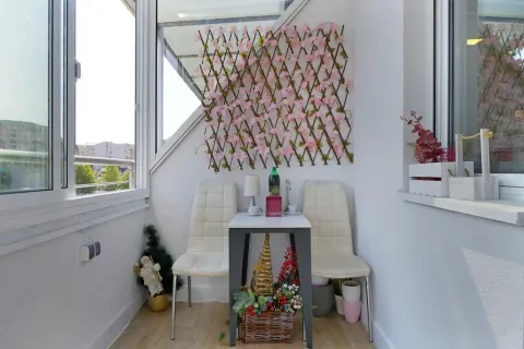 Zastakljeni balkon sa malim stolom, dve stolice i dekorativnim elementima. - image 13