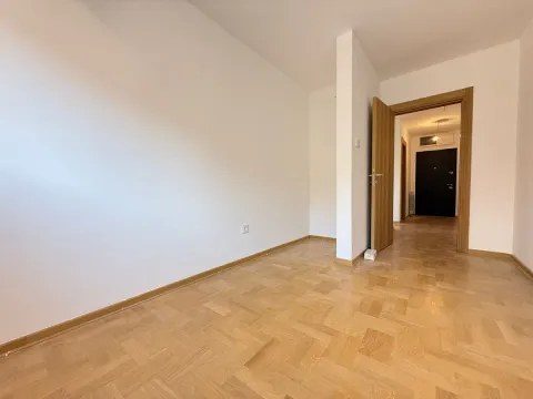 Prazna soba sa parketom i otvorenim vratima koja vode u hodnik. - image 12