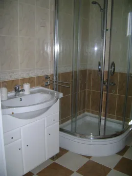 A bathroom featuring a white sink vanity and a glass shower enclosure. - image 8