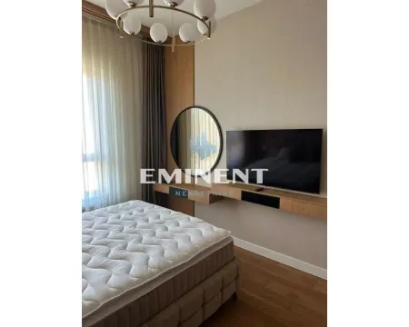 Modern bedroom with a double bed, wall-mounted TV, and a round mirror. - image 10