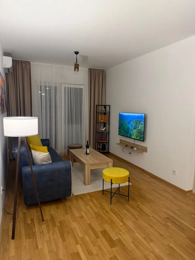Udobna dnevna soba sa garniturom i televizorom.