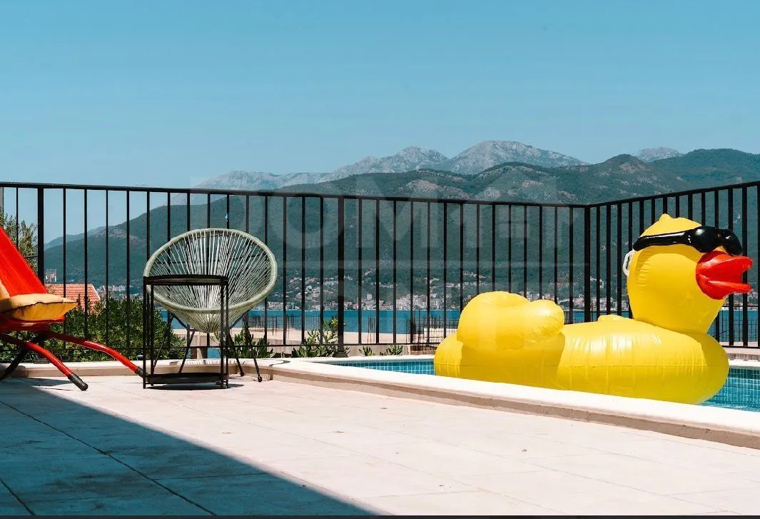 Terrace with a pool and views of the sea and mountains.