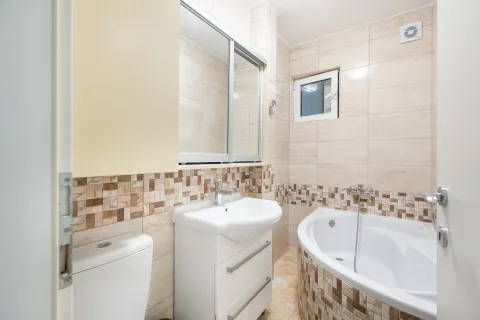 Kupatilo opremljeno umivaonikom, ugaonim ormarićem sa ogledalom i ugaonom kadom. - image 11