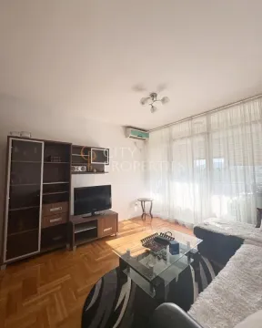 Dnevna soba sa garniturom, TV komodom i izlazom na terasu. - image 5