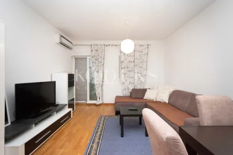 Dnevna soba sa ugaonom garniturom, televizorom i izlazom na terasu. - image 2