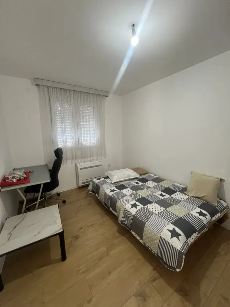 Simple bedroom with a single bed and a study desk.