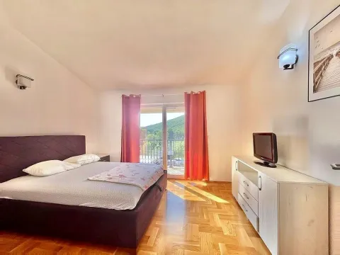 Namještena spavaća soba sa bračnim krevetom, komodom, TV-om i izlazom na terasu. - image 13