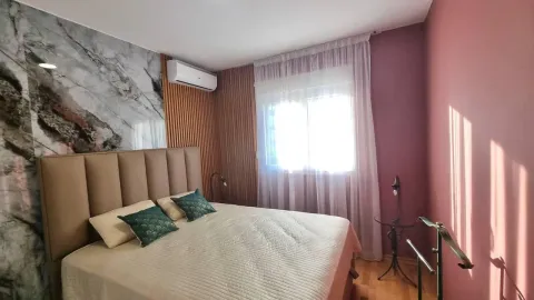 Furnished bedroom with a double bed, air conditioner, and a window with curtains. - image 6