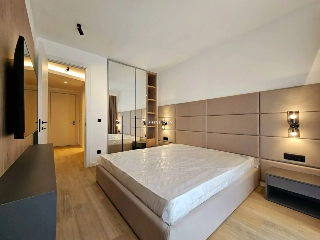 Modern bedroom with a double bed and built-in wardrobes.