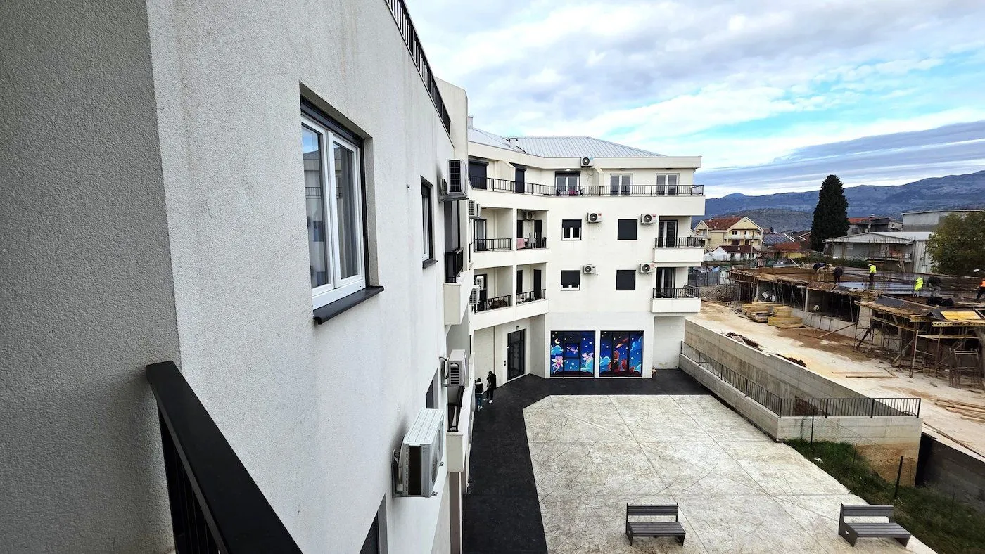 View of the courtyard and residential building facade from the balcony.