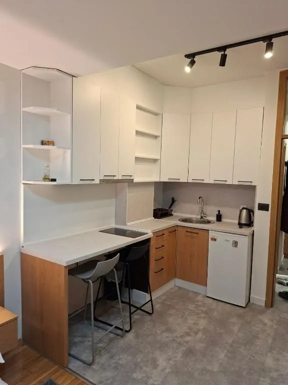Small modern kitchen with white cabinets and a dining bar.