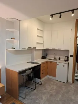 Small modern kitchen with white cabinets and a dining bar. - image 6