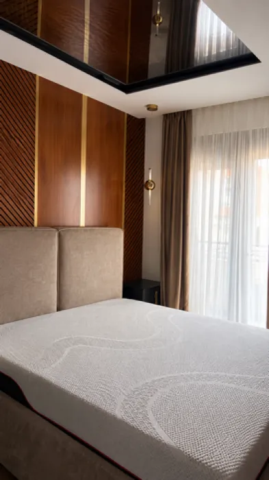 Modern bedroom with a double bed and a wooden wall panel.