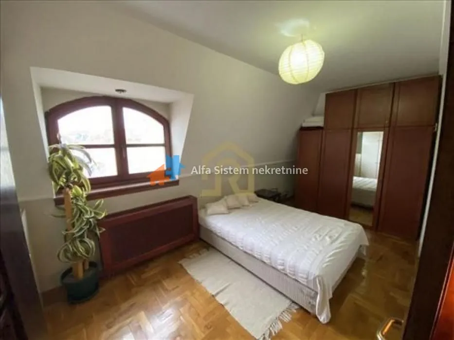 Bedroom with a double bed, wooden wardrobe, and a skylight window.