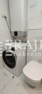 View of the bathroom with a washing machine, water heater, and toilet bowl. - image 10