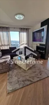 Dnevna soba sa garniturom, stočićem i televizorom na zidu. - image 13