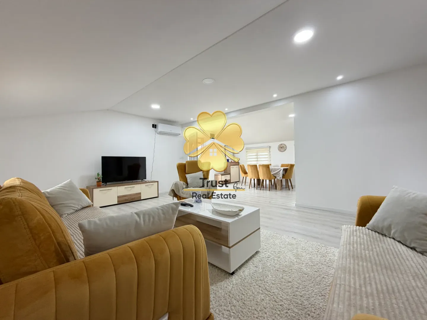 Living room with sofa set, TV, and coffee table.