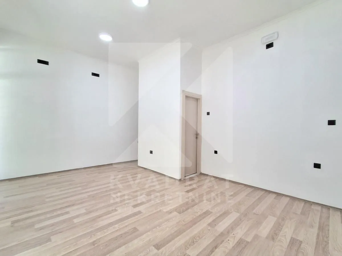 Empty room with white walls and wooden flooring.