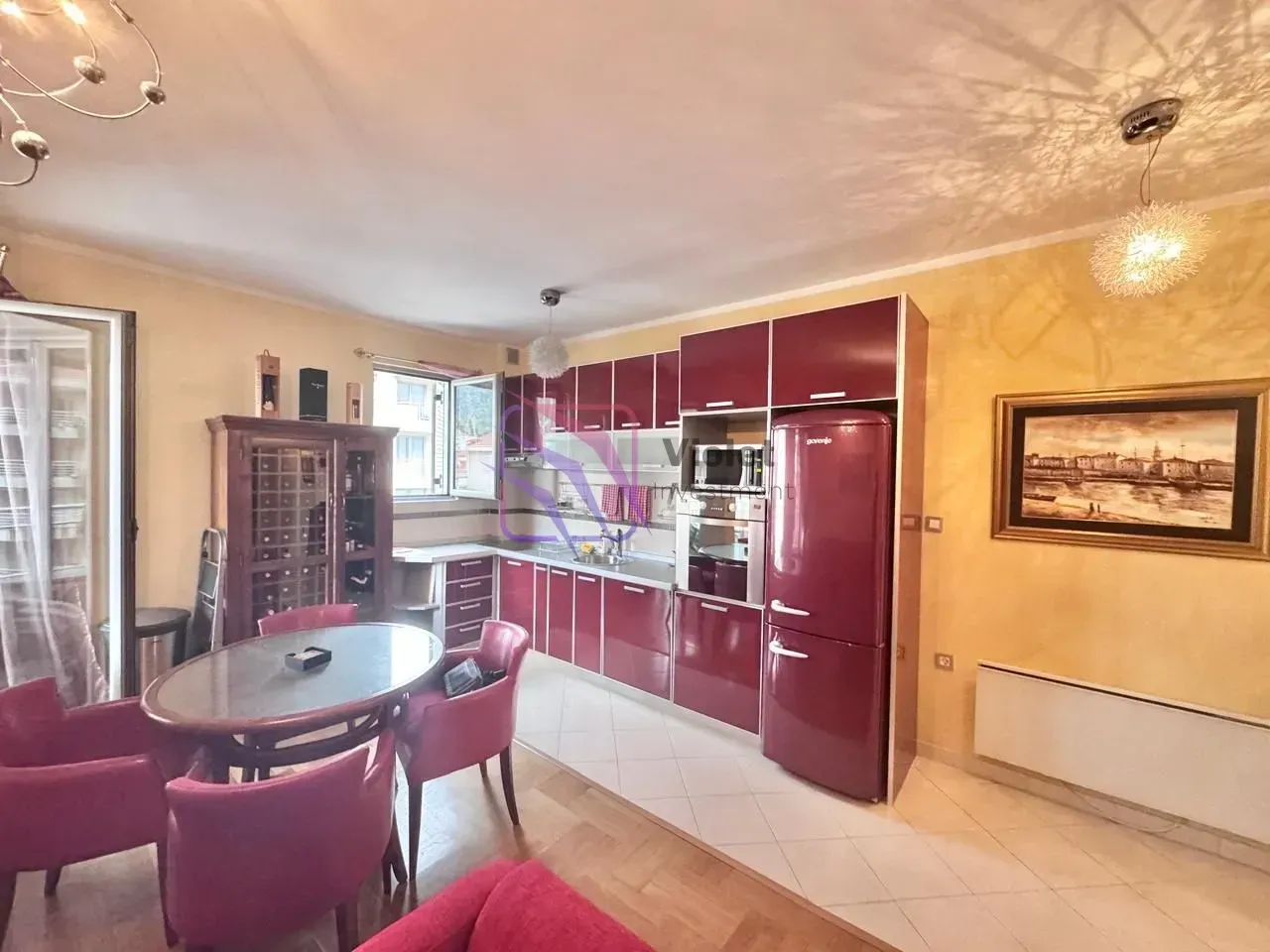 Kitchen with red cabinets, dining table and chairs.