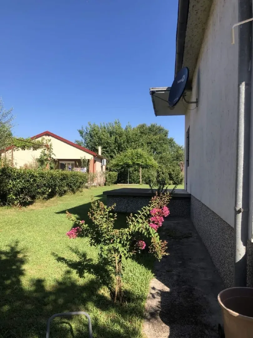 Pogled na uređeno dvorište i bočnu stranu kuće.