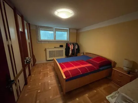 Spavaća soba sa bračnim krevetom, drvenim ormarima i parketom na podu. - image 19