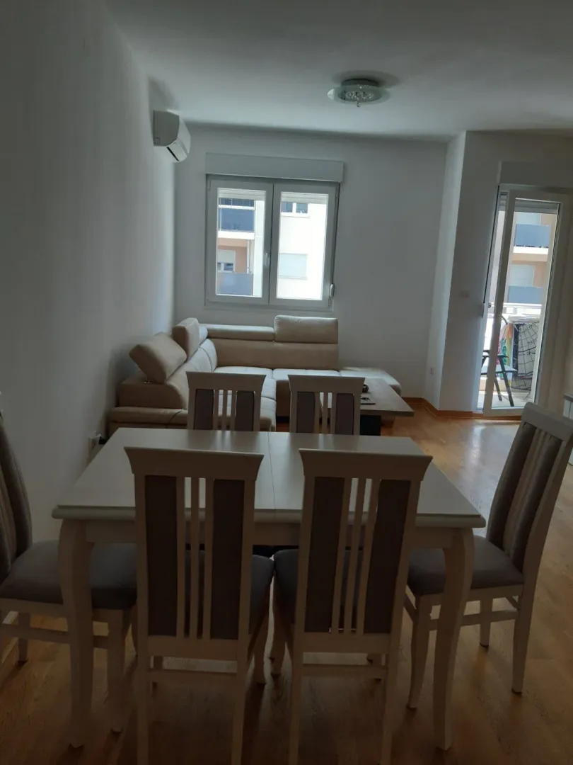 Bright living room with a dining table and a corner sofa.