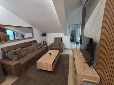 Living room with a sofa set, television, and wooden coffee table. - image 19