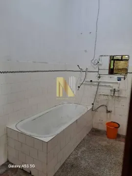 Older bathroom with a tiled bathtub and a wall mirror. - image 8