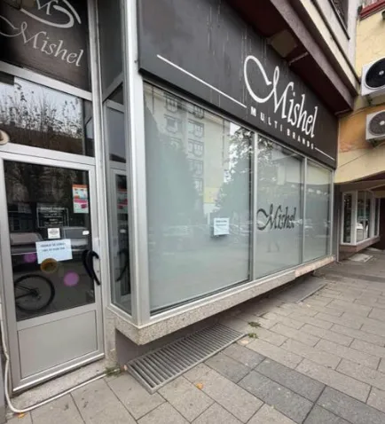Exterior of a commercial space with a display window and company sign.