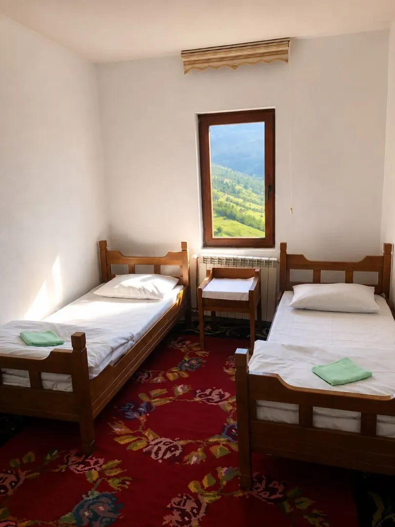 Bedroom with two wooden beds and a view of nature through the window.