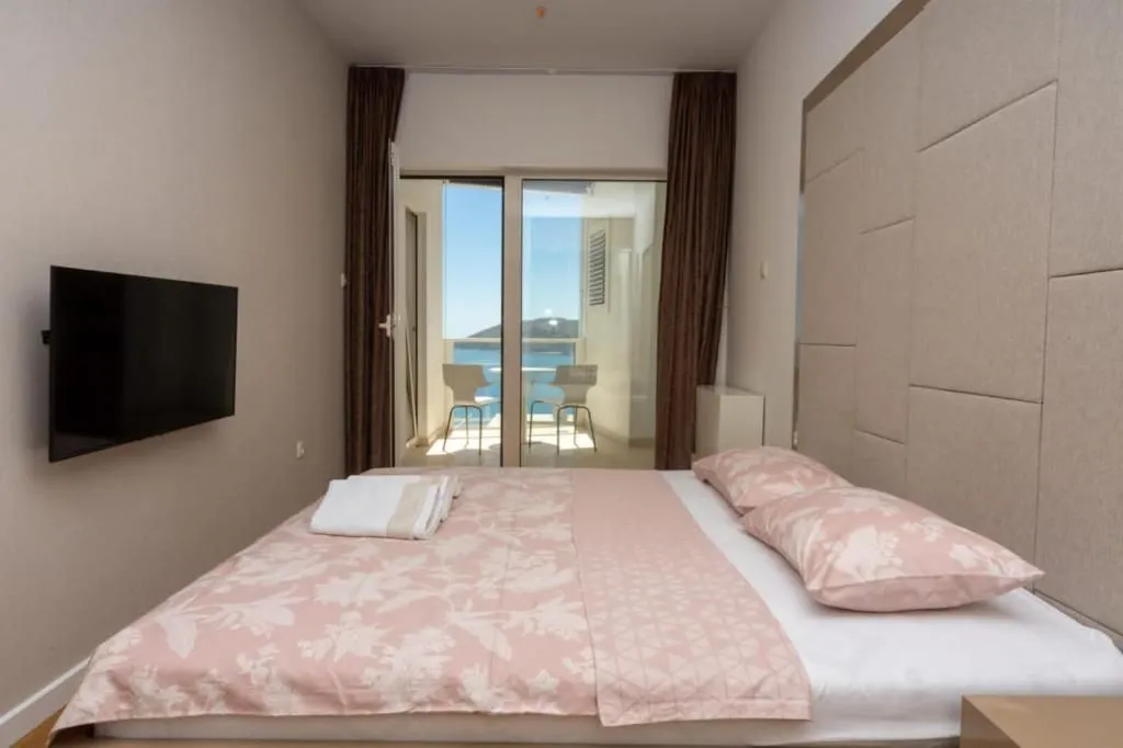 Furnished bedroom with a double bed and access to a terrace with a sea view.