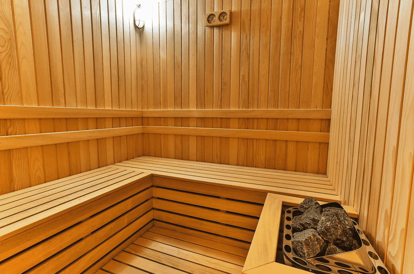 Drvena sauna sa klupama i peći sa kamenjem.