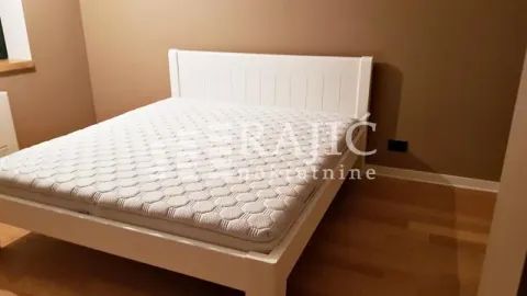 Bedroom with a white double bed and parquet flooring. - image 6