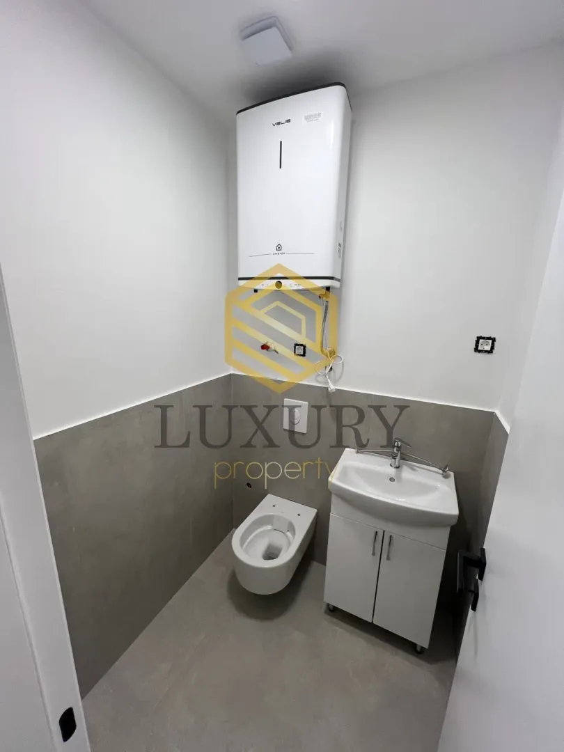Small bathroom with sanitary ware and a water heater.