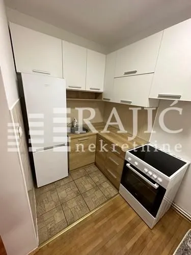 Smaller equipped kitchen with white cabinets and white appliances.