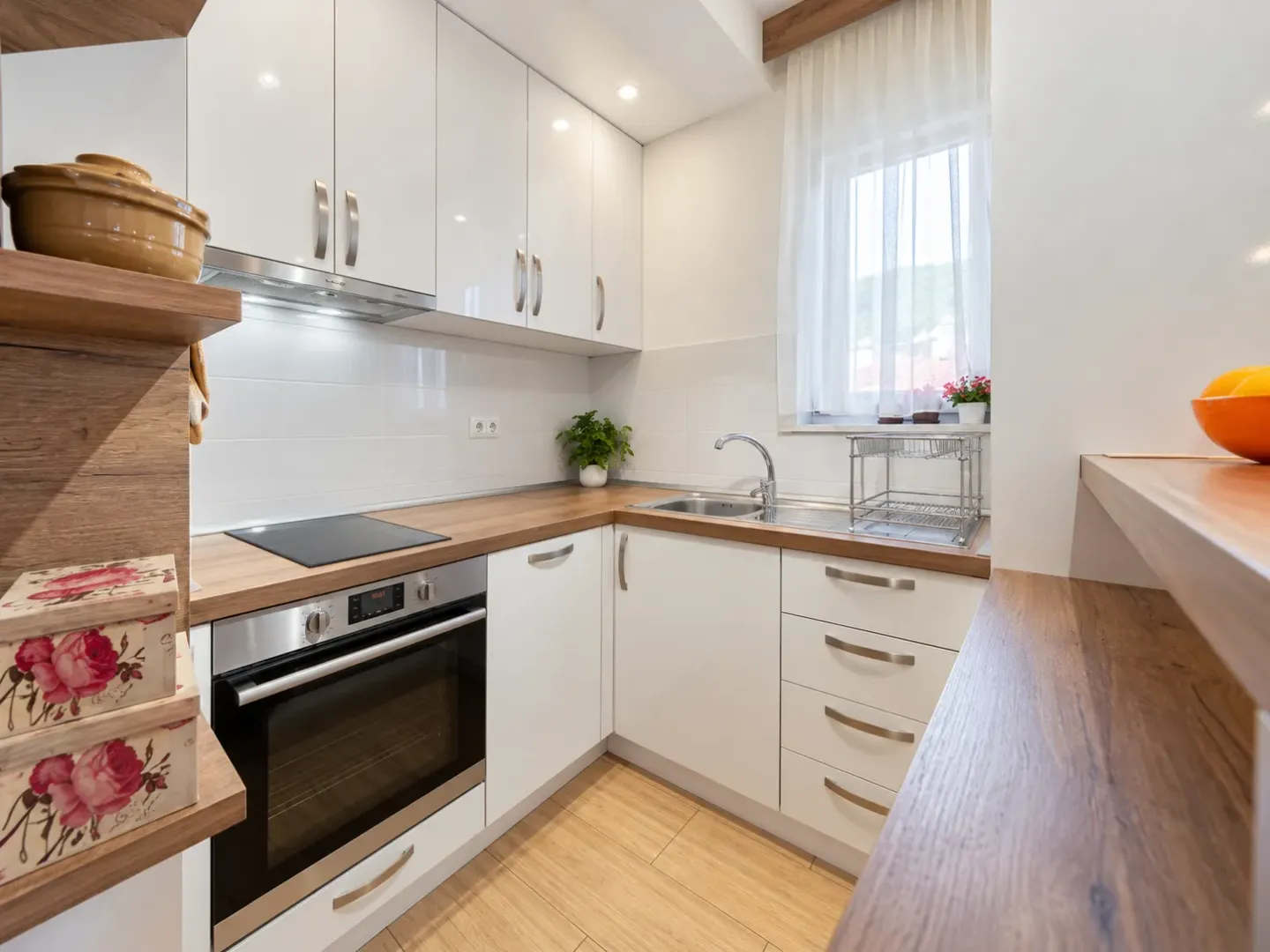 Small modern kitchen with white cabinets and a wooden countertop.