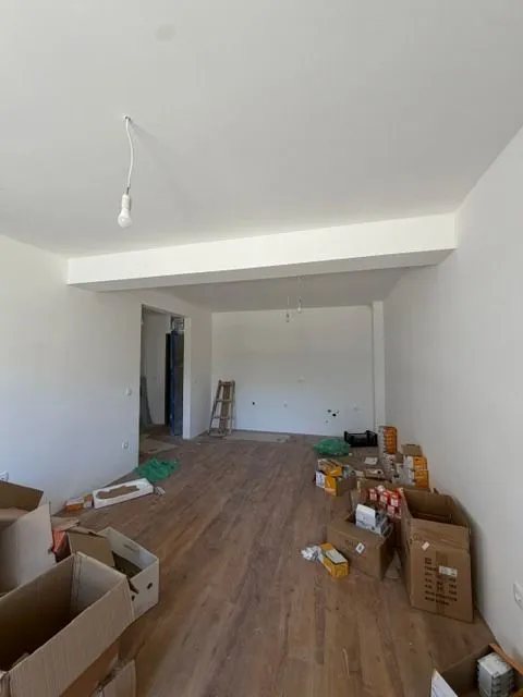 Prazna prostorija u toku renoviranja sa kutijama na podu.