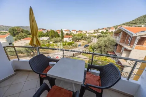 Small furnished balcony with a table, chairs, parasol, and surrounding view. - image 7