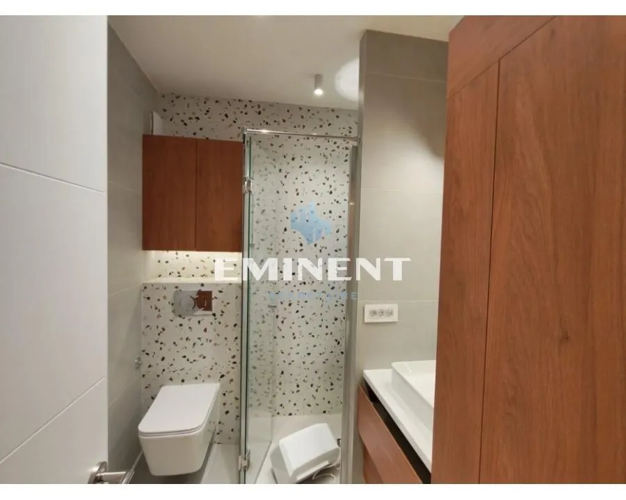Modernly equipped bathroom with a walk-in shower and built-in vanity.