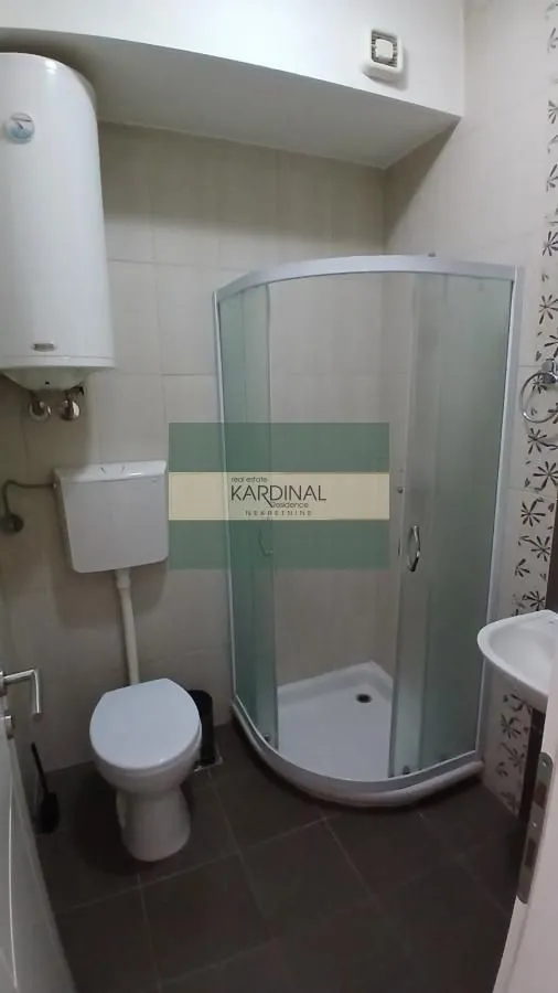 Manje kupatilo sa tuš kabinom, WC šoljom i bojlerom.