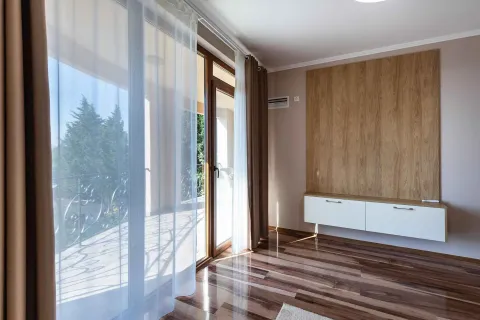 Dnevni boravak sa drvenim panelom na zidu i izlazom na terasu. - image 3