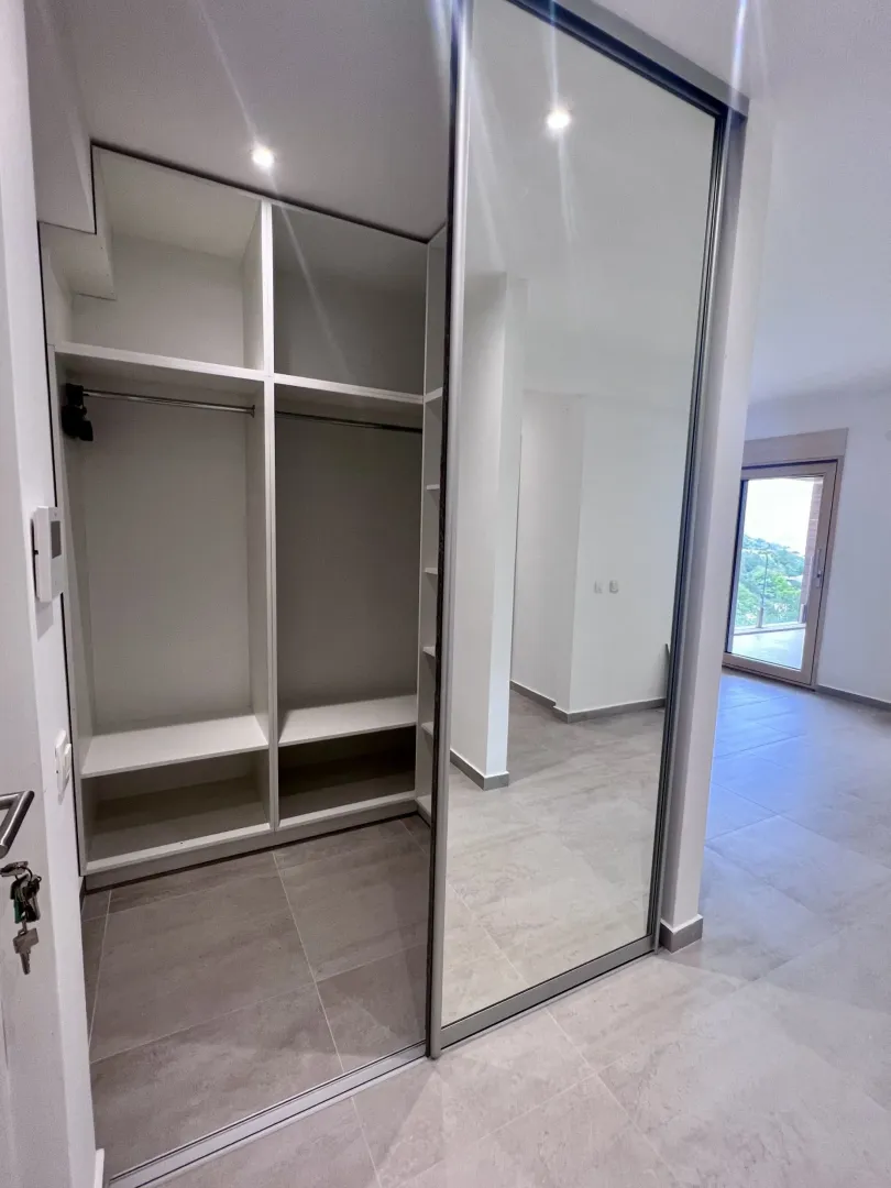 Ugradni plakar sa velikim ogledalom u sobi sa svjetlim podom.