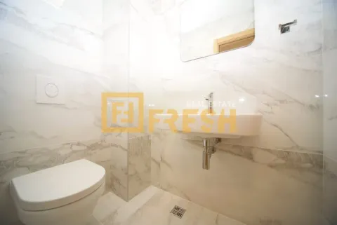 Modern bathroom equipped with white marble tiles, washbasin and toilet. - image 6