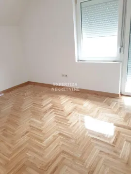 Empty room with parquet flooring and a window. - image 4
