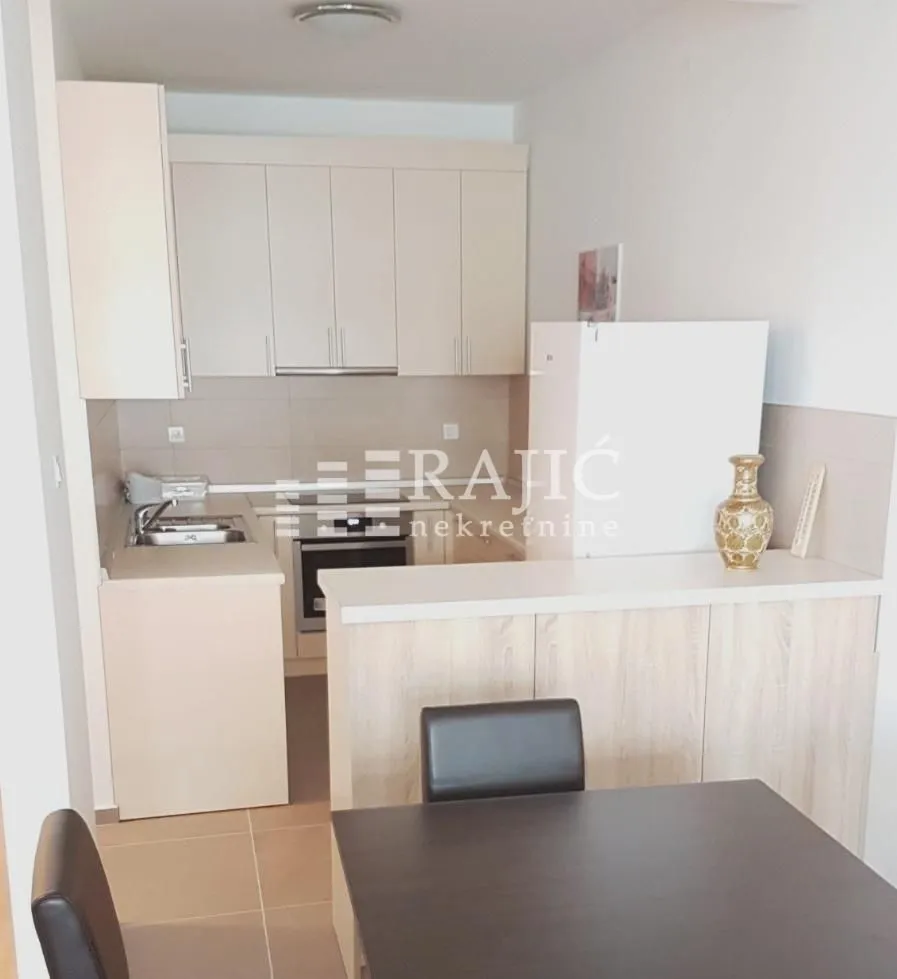 Smaller kitchen with light-colored cabinets and a breakfast bar.