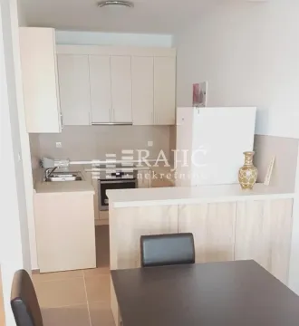Smaller kitchen with light-colored cabinets and a breakfast bar. - image 4