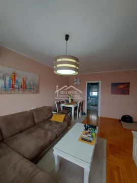 Dnevna soba sa garniturom, stočićem i trpezarijskim delom u pozadini. - image 2