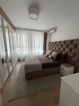 Nameštena spavaća soba sa bračnim krevetom, velikim ormanom i prozorom sa belim zavesama. - image 8
