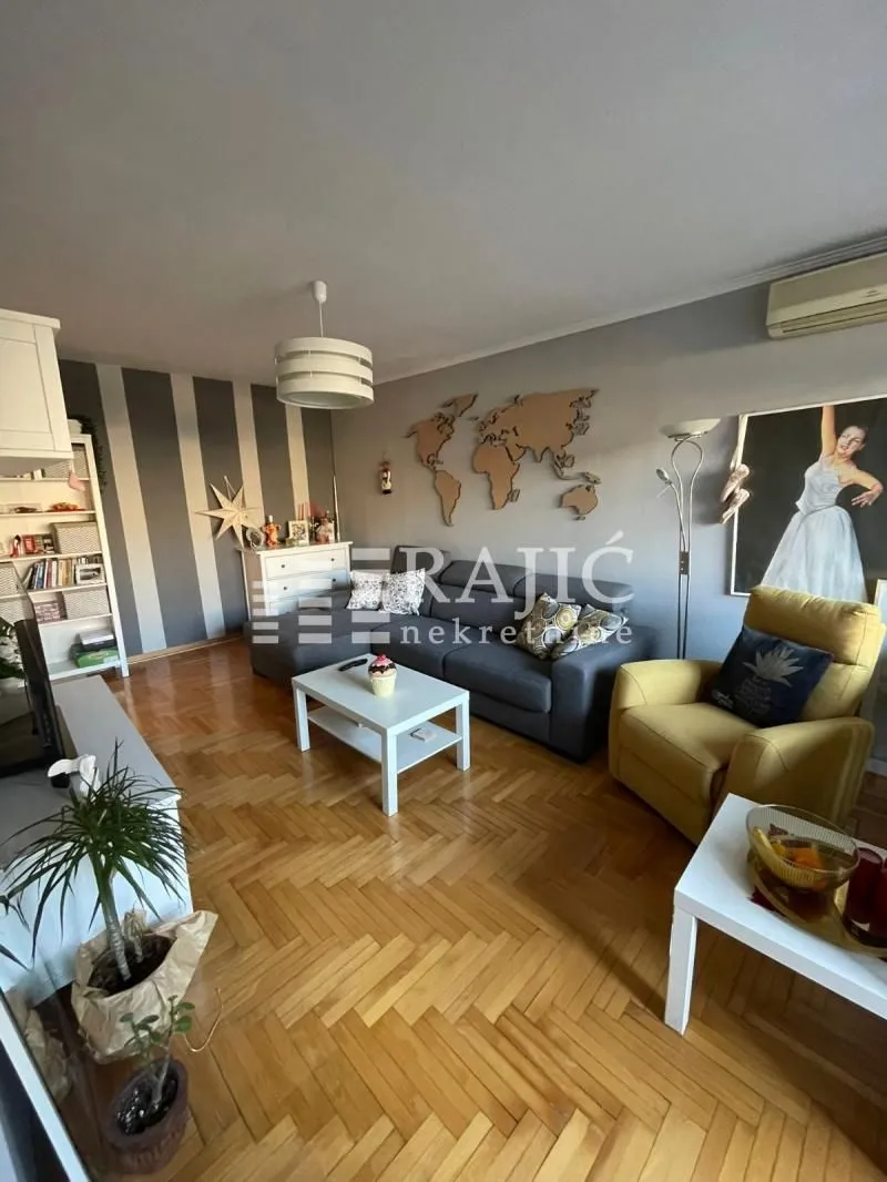 Furnished living room with a sofa and parquet flooring.