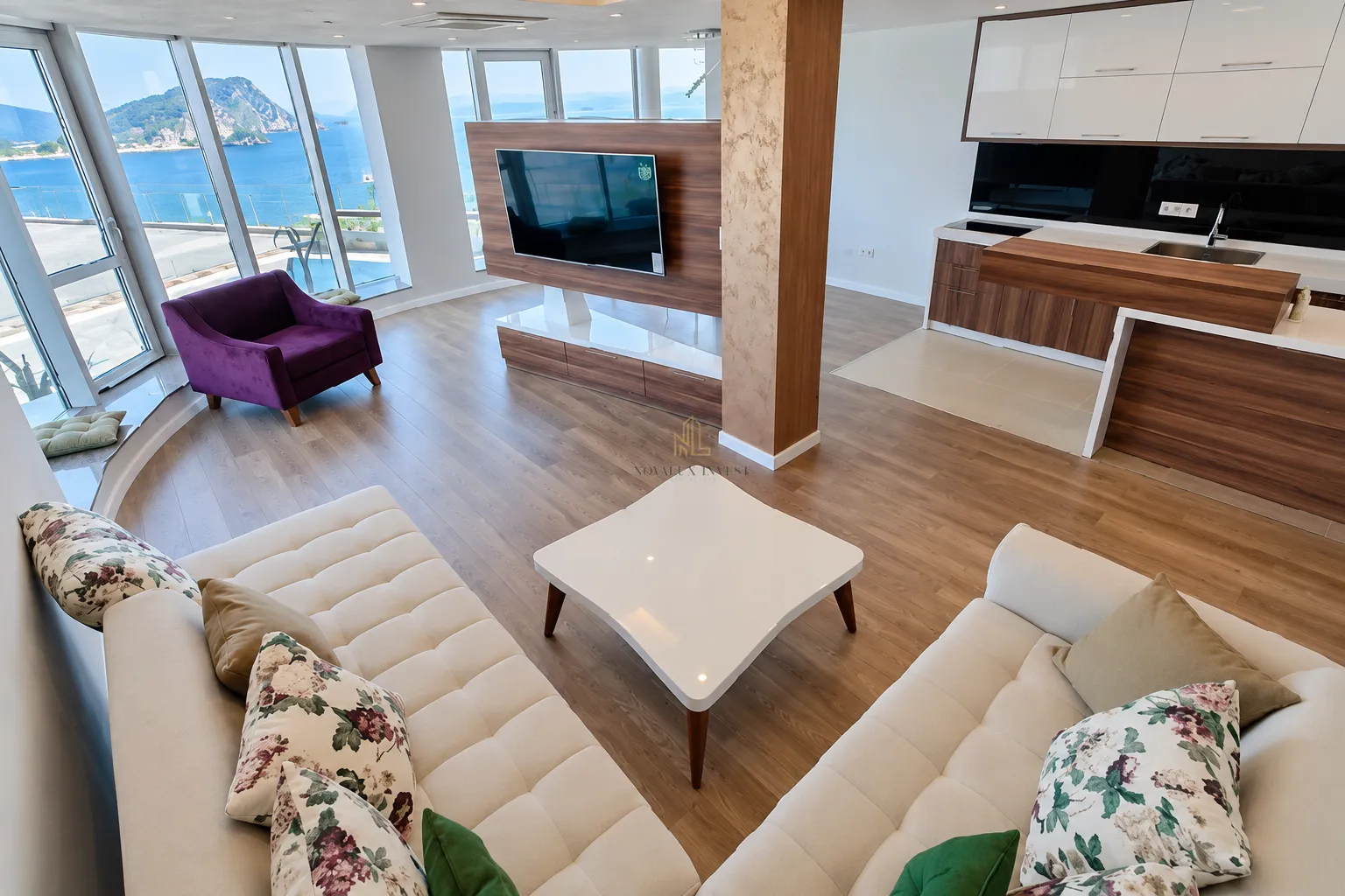 Modern open-plan space with a living room, kitchen, and sea view.